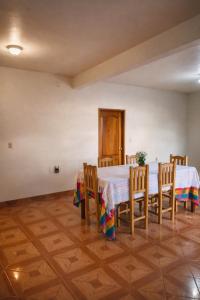 a dining room with two tables and wooden chairs at Hospedaje Rayo De Sol in Tepoztlán