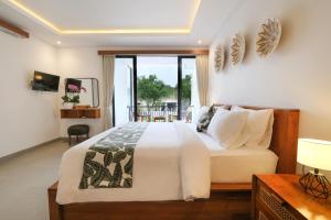 a bedroom with a large bed and a balcony at Emerald Villas Canggu in Canggu +48 photos