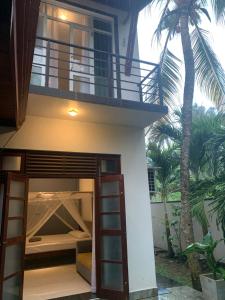 a house with a bunk bed under a balcony at Menuks villa in Habaraduwa Central