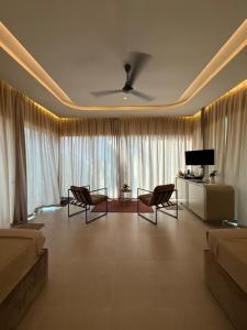 a living room with chairs and a couch and a television at Ceylan trees in Kataragama