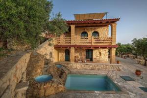 a house with a swimming pool in front of it at Diamond Suites in Vasilikos