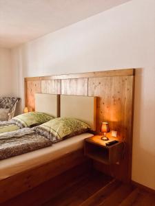 a bedroom with a large wooden headboard and a bed at Ferienwohnung Mariengrund in Schönau am Königssee