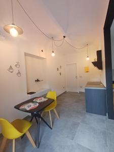 ein Esszimmer mit einem Tisch und gelben Stühlen in der Unterkunft casa cinna in Montà