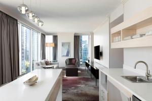 a kitchen with white counters and a living room at Loews Atlanta Hotel in Atlanta