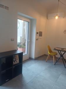 ein Wohnzimmer mit einem Tisch und einem gelben Stuhl in der Unterkunft casa cinna in Montà