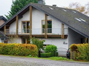 a white house with a porch and a balcony at Landhaus Kummerfrei in Hellenthal