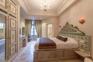 a bedroom with a king sized bed and a bathroom at Maison d'Hôtes Dar Ennassim in La Marsa