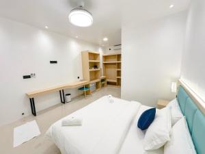 a white room with a bed and a desk at LVIS Pool Villa in Dharavandhoo +1 photo