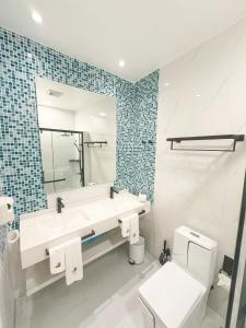 a bathroom with a sink and a toilet and a mirror at LVIS Pool Villa in Dharavandhoo