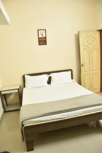 a bed sitting in a room with a door at GA Fernandes house in Colva