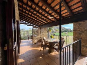 a patio with a table and chairs on a balcony at Mas Vermell in Fontanilles