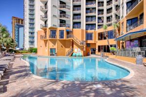 a swimming pool in front of a building at The Patricia Grand in Myrtle Beach