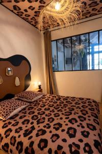 a bedroom with a bed with a cheetah print bedspread at Studio Savane - 5 min du Zoo - CLIM in Seigy