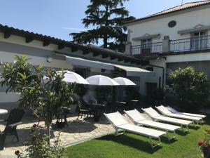 a row of white lounge chairs in front of a building at B&B Villa Prestigio in Novi Ligure