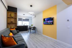 a living room with a couch and a table at Rezidential Bacovia Orange by Rooms in Bacău