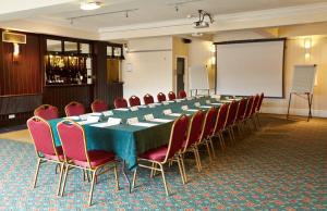 a conference room with a long table and chairs at Raven Hotel by Greene King Inns in Hook