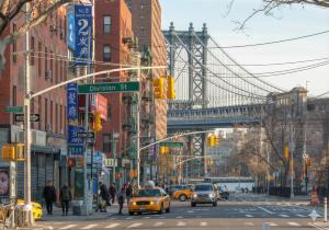 a busy city street with a bridge in the background at Comfortable 2BR & 2 Bath Apt in Downtown NYC in New York +5 photos