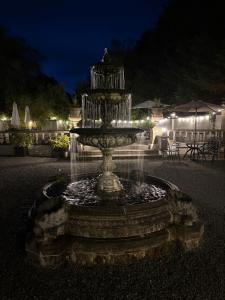 a fountain in the middle of a yard at night at Meifod country house hotel in Caernarfon