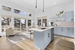 a kitchen with white cabinets and a table and chairs at Bay View Loft in Lincoln City