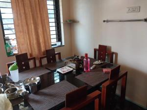 a dining room with a table with chairs and a tableablish at Saraswati Sadan in Hospet
