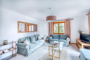 a living room with two blue couches and a tv at Centrally located with great views and terrace in Champéry