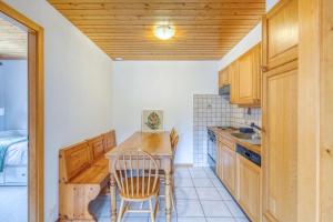 a kitchen with wooden cabinets and a table and chairs at Centrally located with great views and terrace in Champéry