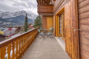 a balcony with a table and chairs and mountains at Centrally located with great views and terrace in Champéry