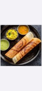 a plate of food with bread and some dipping sauces at Infinity 555 Lodge in Lusaka