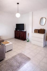 a living room with a flat screen tv on a cabinet at Private Room in Corroios 15 Minutes from the Beach - Quarto Privado em Corroios com Fácil Acesso à Praia e Lisboa in Corroios