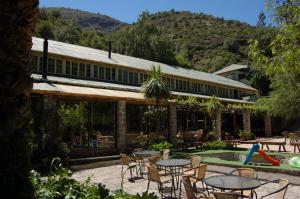 a patio with tables and chairs next to a pool at Hostería Millahue in San José de Maipo