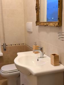 a bathroom with a sink and a toilet and a mirror at il canto del lago in Iseo +8 photos