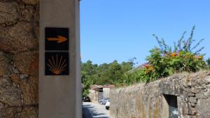 a sign on the side of a stone wall at Albergue Ultreya in Esposende