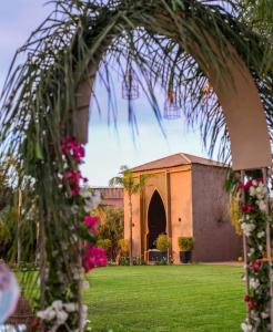 an archway with flowers in front of a building at Fekhara CC in Marrakesh