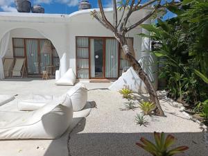 a patio with a white couch and a tree at Sal Central in Uluwatu