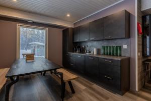 a kitchen with black cabinets and a table at Saimaa LIGHT in Imatra