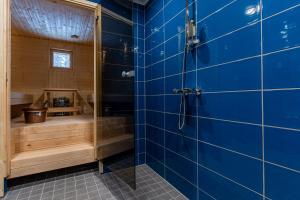 a blue tiled bathroom with a shower and a tub at Saimaa LIGHT in Imatra +29 photos