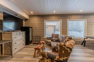 a living room with couches and a tv and a table at Saimaa LIGHT in Imatra