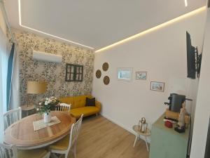 a living room with a table and a yellow couch at Galamares Nest in Sintra