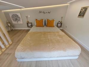 a large bed in a room with orange pillows at Galamares Nest in Sintra