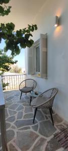two chairs and a table on a patio at Dandelion Paros Apartments IV in Kóstos