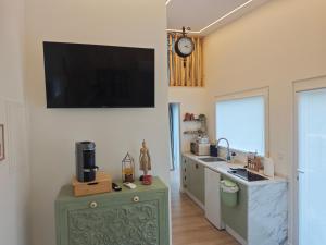 a kitchen with a tv hanging on the wall at Galamares Nest in Sintra