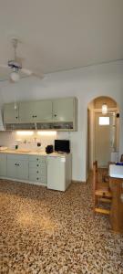 a large kitchen with white cabinets and a table at Dandelion Paros Apartments IV in Kóstos +19 photos