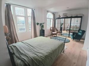 a bedroom with a bed and a chair and a mirror at Mi casa es su casa in Ghent
