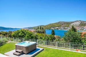 a hot tub in a garden with a view of the water at Villa High Life in Seget Vranjica