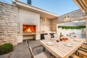 a dining room with a table and a fireplace at Villa High Life in Seget Vranjica