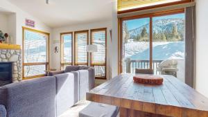 a living room with a table and a view of the mountains at Snowcreek V #777 in Mammoth Lakes