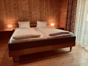 a bed in a wooden room with two lamps on tables at Villa Florl in Schladming