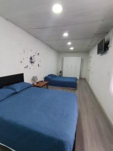 a bedroom with two beds and a tv on the wall at Villablanca in Cuenca