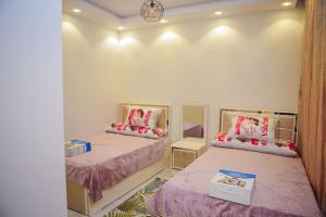 a bedroom with two beds and a mirror at الزقازيق in Kafr Muḩammad Ḩusayn