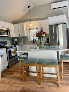 a kitchen with a table with chairs and a vase of flowers at The Beach Gallery in Narragansett +22 photos